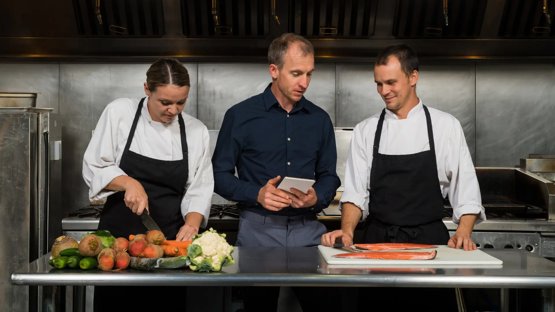 Enterpreneur in his commercial kitchen with chef and sou-chef